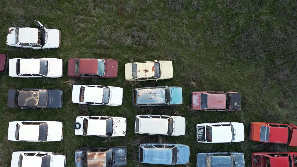 Voitures abandonnées alignées dans un champ, vue aérienne